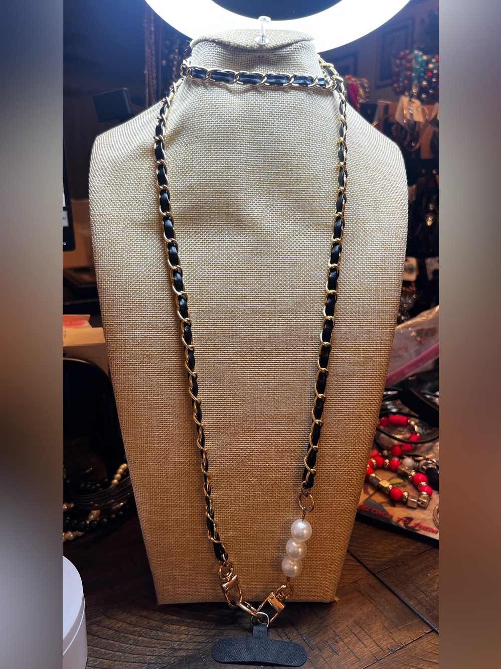 Cross body Black and Gold Chain Necklace with Pearl Accent holds cell phone